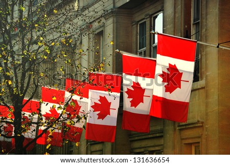 a row of Canadian flags outside Canada House in Trafalgar Square, London