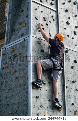 LONDON, UK - SEPTEMBER 7TH, 2014: a person climbing up a wall at a street fair in Woolwich Arsenal, London, UK.