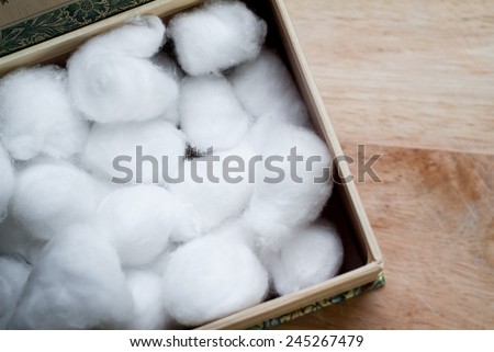 closeup photo of a cardboard box full of white cotton balls