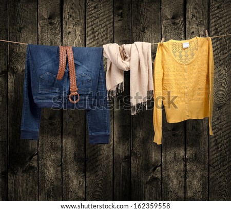 Women\'s clothing on a clothesline on wood background