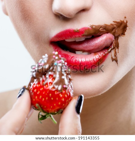 Seduction - red female lips with chocolate mouth , holding strawberries