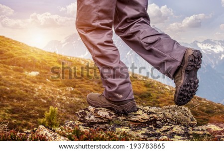 Hiker  standing on top of a mountain and enjoying sunrise