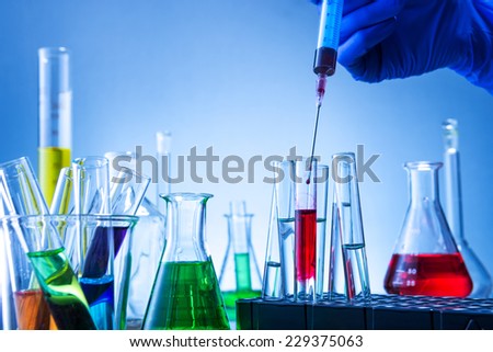 Laboratory equipment, lots of glass filled with colorful liquids and hand injection
