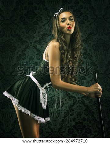 Vintage pin up maid's uniform, holding a broom