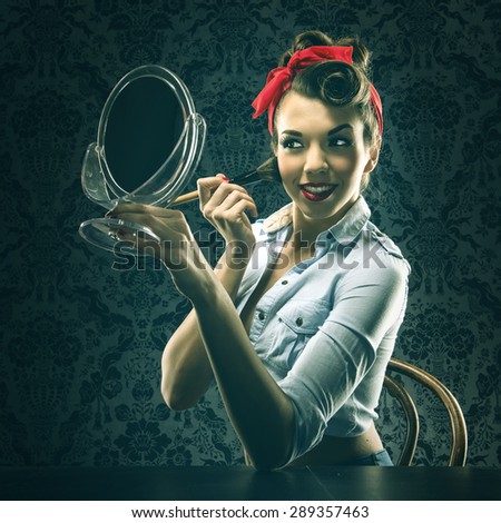 Vintage woman holding a mirror and makeup brush
