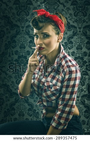 Vintage woman in old room smoking a cigarette