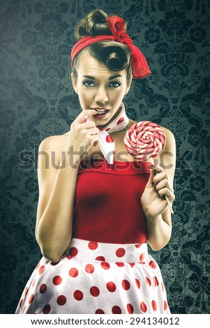 Pretty sexy woman in red vintage polka dot dress - with lollipop