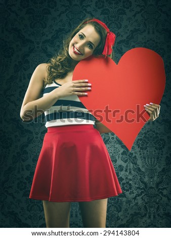 Pretty vintage woman holding a huge heart