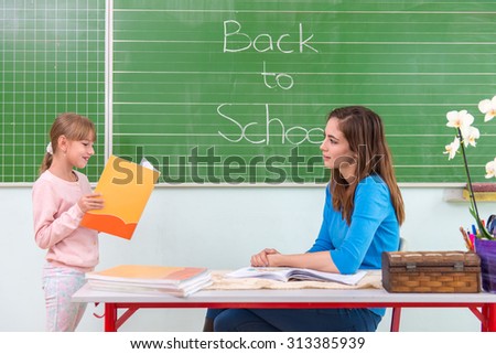 Students read a woman teacher at the blackboard