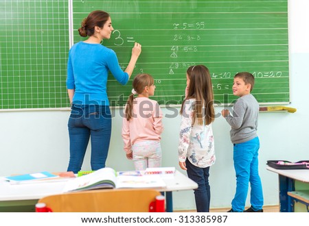 Teacher and student at the blackboard, math class
