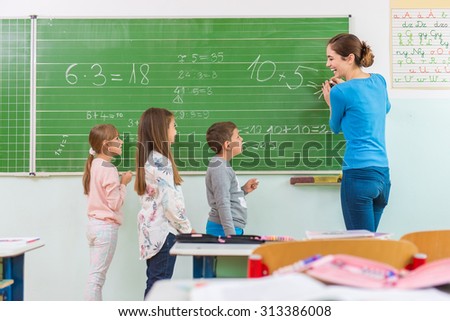 Teacher and student at the blackboard, math class