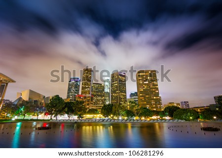 Downtown Los Angeles skyline reflects in water at night.