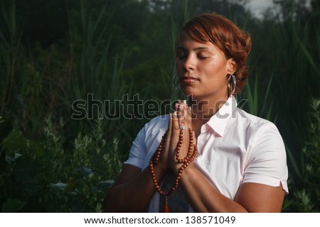 Portrait of African American woman praying outdoors at night.