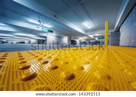 Grunge industrial room interior with safety yellow bumps panel on floor. Copyspace.
