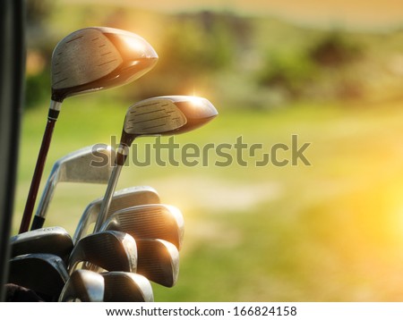 Golf clubs drivers over green field background