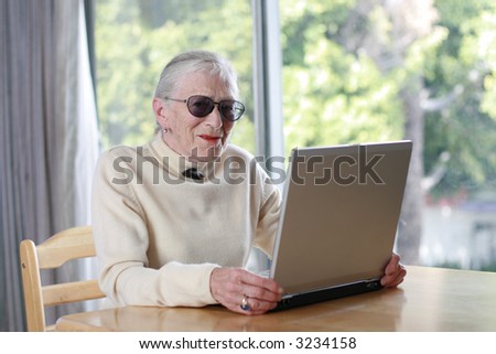 Elderly lady with laptop. Shallow DOF.