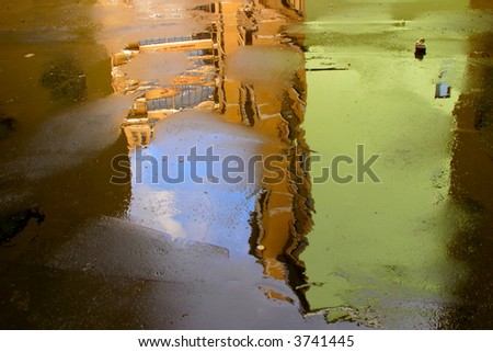 Abstract background made of old buildings reflecting in a wet asphalt.