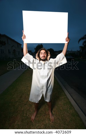 Crazy man with blank billboard sign on a street at night.
