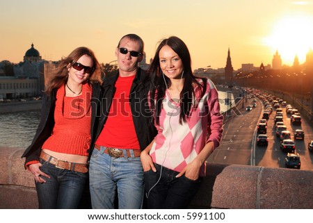 Man and two beautiful young women in Moscow city at sunset. Russia.