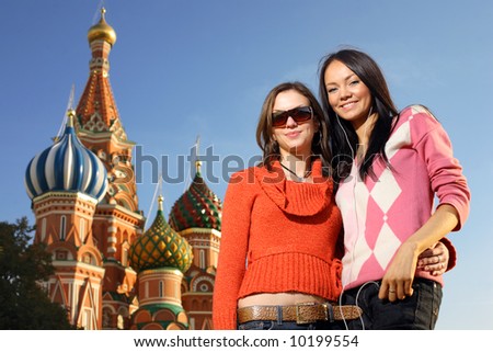 Two beautiful young women next to Saint Basil\'s Cathedral in Red Square, Moscow, Russia.