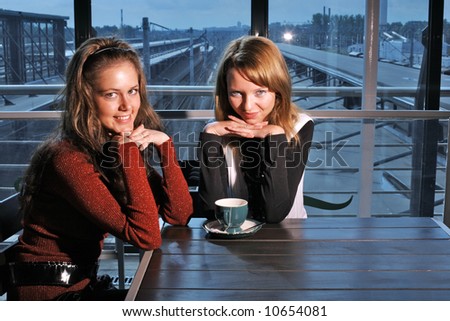 Two beutiful young women in restaurant with cup of tea
