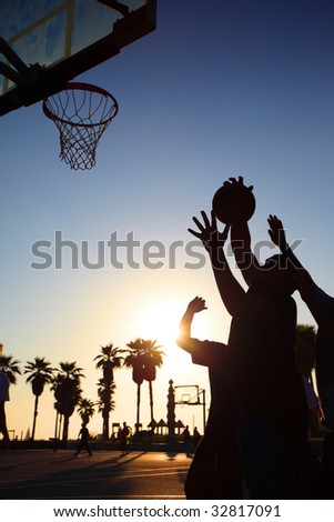 Basketball players silhouettes at sunset