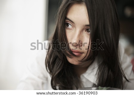 Portrait of beautiful young woman thinking. Close-up, shallow DOF.