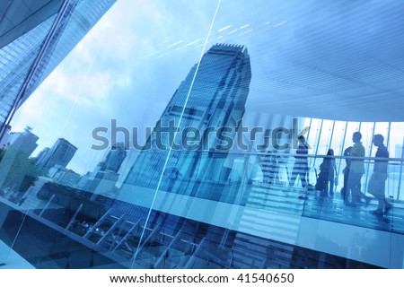 Abstract modern city background with people walking over buildings reflections.