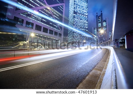 Fast moving cars lights blurred over modern city background
