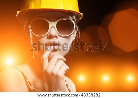 Portrait of fashionable female construction worker over glowing lights background