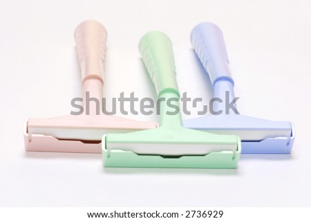 three disposable razors with safety caps on white background