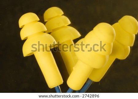 yellow ear plugs on a black background