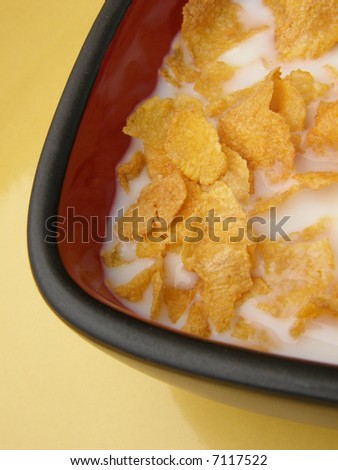 corn flaked cereal in square bowl on yellow background