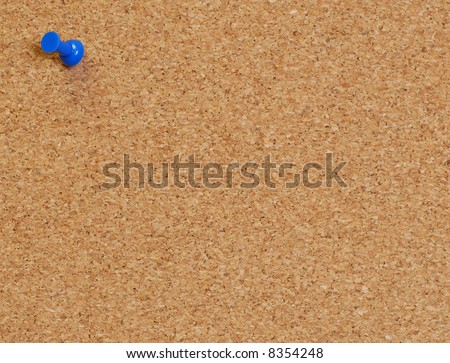 cork board with blue push pin or thumb tack
