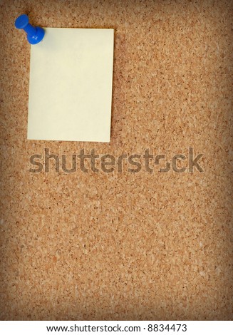cork board with note attached with thumb tack