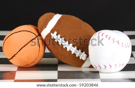 stuffed basketball, football and baseball on black and white checkered floor