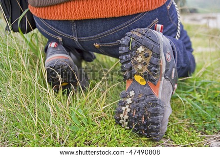 A very closed image of a crouched down man in the nature
