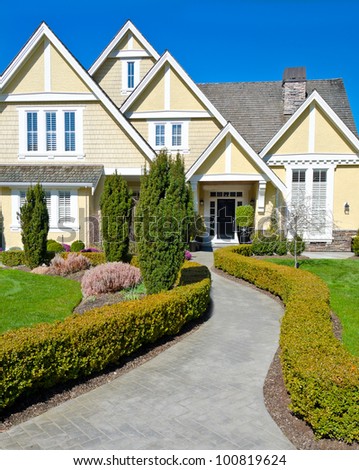 Fragment of the big luxury  home with nicely trimmed bushes at the doorway  in the suburbs of Vancouver, Canada