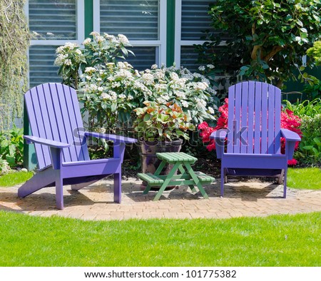 Colorful wooden lawn chairs at the front        ( back ) yard.