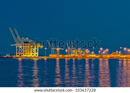 Container port terminal with reflection on the water at disk (dawn, night ) in Tsavassen, Vancouver,  BC
