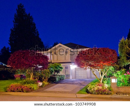 A house in suburbs at dusk ( night ) with nicely landscaped front yard in Vancouver, Canada