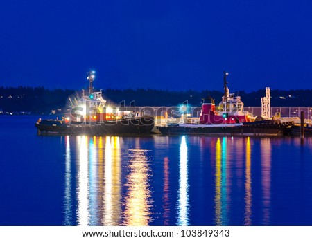 Two tug boats ( tow-boats ) at night time.