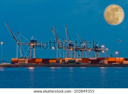 Container port terminal at night ( dawn, dick ) time with big moon in the sky.