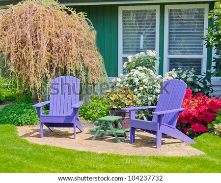 Two  wooden lawn chairs at the front        ( back ) yard in sunny day.