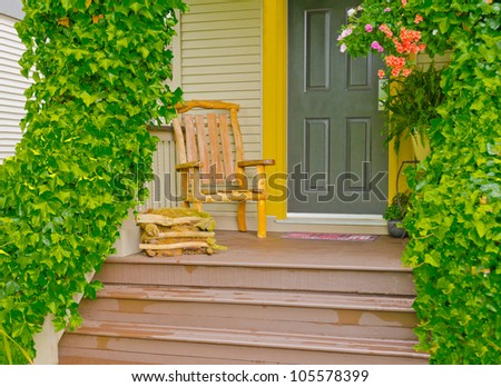 Entrance of a house with the hand made wooden chair on the porch and ivy on the rails