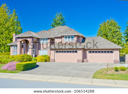 Custom built big luxury house with two double garage doors in a residential neighborhood. Suburbs of Vancouver ( Surrey ) Canada.