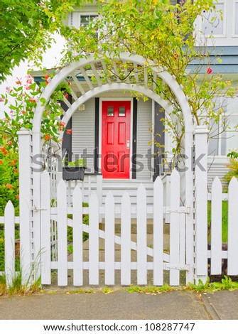 Arch wooden entrance with the fence, cowered with flowers
