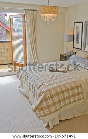 Nicely decorated contemporary bedroom with open door on to the balcony at the day time. Interior design.