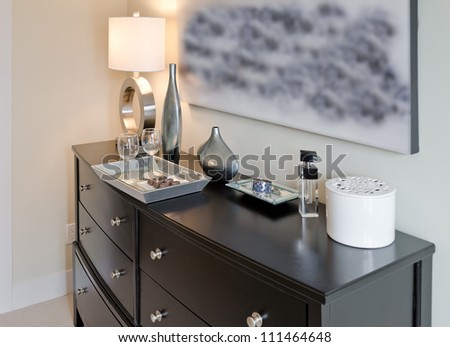 The dresser with the tray with chocolate candies and wine glasses and ceramic vases. Interior design