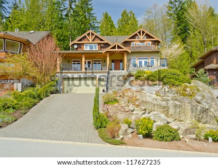 Big custom made luxury house with nicely landscaped front yard in the suburbs of North Vancouver, Canada.